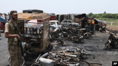Afisa wa kulinda usalama anasimama katika eneo ambapo watu wapatao 140 walipoteza maisha yao baada ya lori la mafuta kulipuka nchini Pakistan tarehe 25, Juni, 2017.