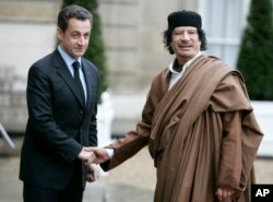 FILE - In this Dec. 10 2007 file photo, French President Nicolas Sarkozy, left, greets Libyan leader Col. Moammar Gadhafi upon his arrival at the Elysee Palace, in Paris.