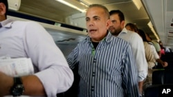 Venezuelan opposition leader Manuel Rosales, center, stand as he waits to leave a plane after it landed at La Chinita airport in Maracaibo, Venezuela, Thursday, Oct. 15, 2015. Rosales a former governor, who had been living in exile since 2009, was arrested when he returned to Venezuela and is expected to appear in a Caracas court later in the day. Rosales ran for president in 2006 and lost to Hugo Chavez.