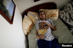 Jesus Ibarra, a 19-year-old engineering student who was injured during a protest against Venezuela's President Nicolas Maduro's government, lies on a bed inside his home in Caracas, Venezuela, Aug. 15, 2017.