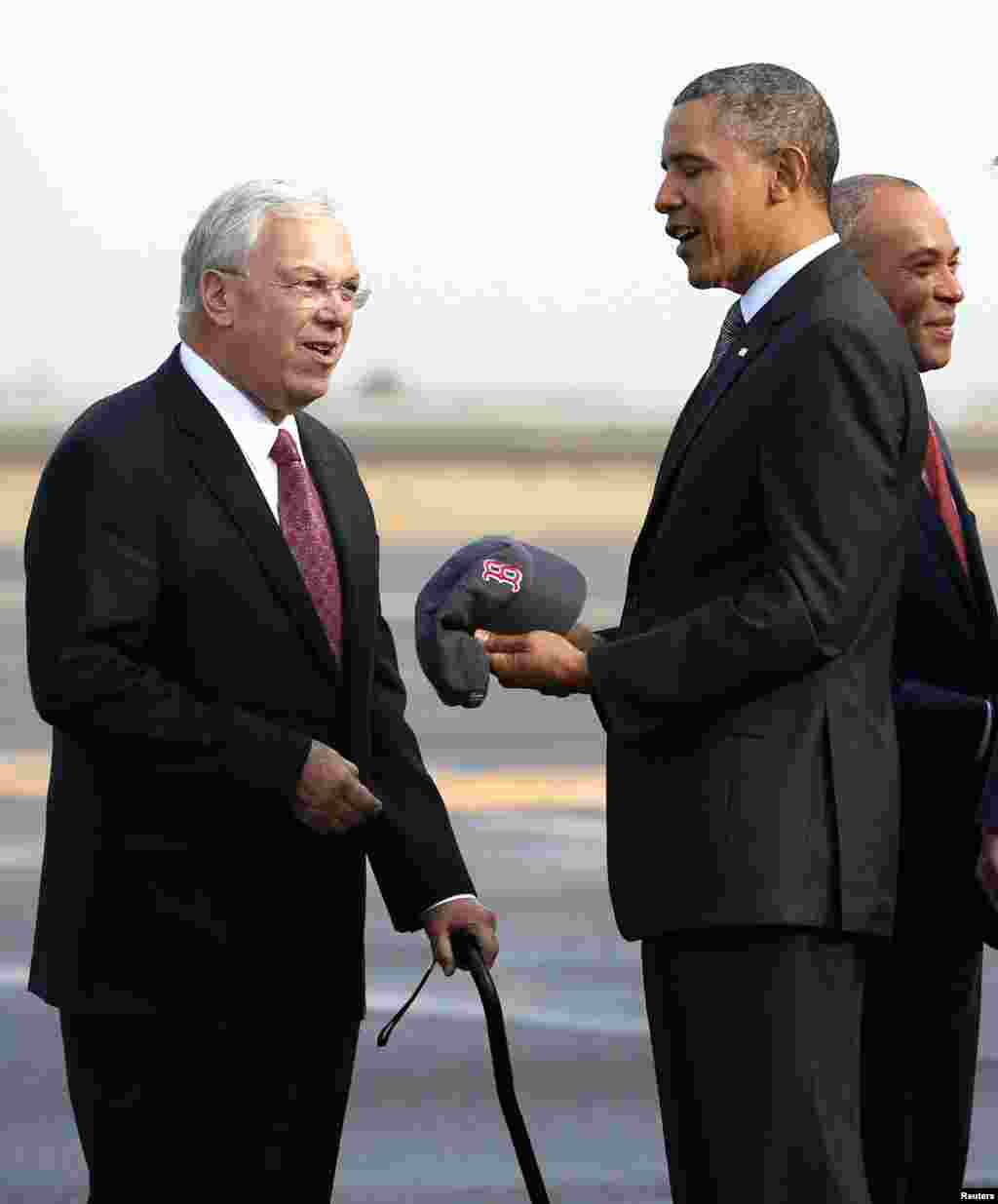 U.S. President Barack Obama is given a Red Sox baseball cap by Boston Mayor Thomas Menino upon his arrival in Boston October 30, 2013. Fans in Boston could be celebrating a World Series title at Fenway Park for the first time in 95 years when the Red Sox 