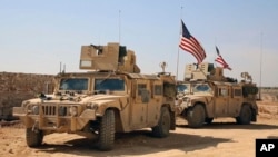 FILE - U.S. forces take up positions on the outskirts of the Syrian town of Manbij, a flashpoint between Turkish troops and allied Syrian and U.S.-backed Kurdish fighters, March 7, 2017.