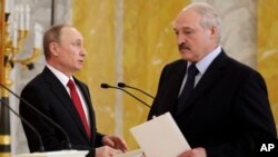Russian President Vladimir Putin, left, and Belarus' President Alexander Lukashenko arrive at their news conference following the talks at Konstantin palace in St. Petersburg, Russia, April 3, 2017. 