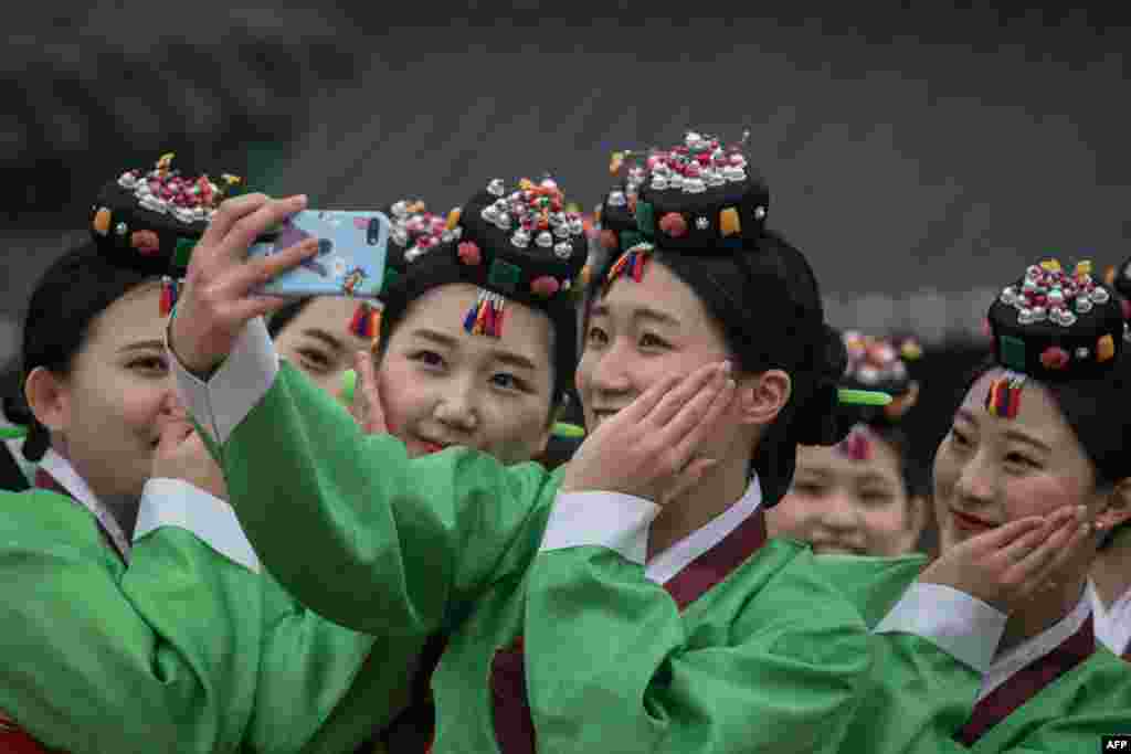 South Korean students pose for a selfie following a traditional coming-of-age ceremony at Namsangol Hanok village in Seoul.
