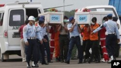 Para anggota Basarnas membawa peti jenazah penumpang AirAsia QS8501 di bandara Pangkalan Bun untuk diangkut ke Surabaya (19/1).