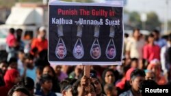People hold placards at a protest against the rape of an eight-year-old girl, in Kathua, near Jammu, a teenager in Unnao, Uttar Pradesh state, and an eleven-year-old girl in Surat, in Ahmedabad, India, April 22, 2018.