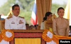 FILE - Thailand's Crown Prince Maha Vajiralongkorn (L) and Royal Consort Princess Srirasmi watch the royal plowing ceremony in Bangkok.