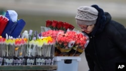 Seorang perempuan lansia mencium bunga yang dijual di jalanan kota Minsk, Belarus, pada Hari Perempuan Internasional (IWD), 7 Maret 2019. IWD merupakan hari libur di Belarus, ditandai dengan pemberian bunga dan hadiah dari pria untuk saudara, teman atau rekan kerja perempuan.