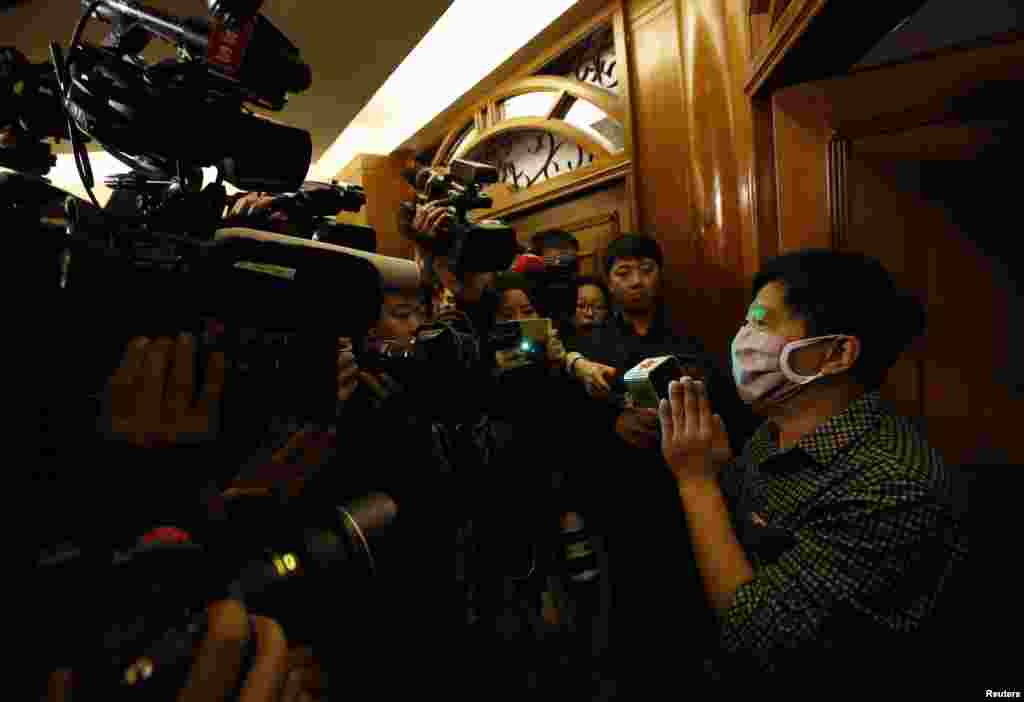 A family member of a passenger onboard the missing Malaysia Airlines Flight MH370 talks to reporters in a hotel in Beijing, March 14, 2014.