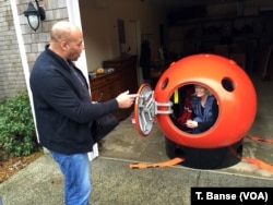 Survival Capsule President Julian Sharpe gives some tips to his first U.S. customer, Jeanne Johnson.