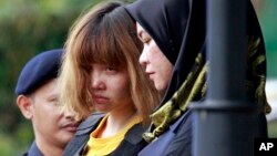 Vietnamese suspect Doan Thi Huong, center, in the ongoing assassination investigation, is escorted by police officers out from Sepang court in Sepang, Malaysia on Wednesday, March 1, 2017. (AP Photo/Daniel Chan)