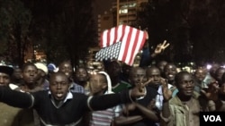 Kenyans holding U.S. flag celebrate in the streets after hearing U.S. President Barack Obama has arrived in Nairobi, July 24, 2015. (Aru Pande / VOA)