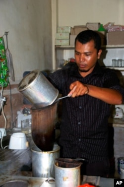 Arfian makes Coffee at his cafe after tsunami recovery program. Photo by Christoph Ernesti