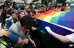 An anti-homosexuality protester, left, who tries to block a parade is taken away by police during the Korea Queer Culture Festival in Seoul, South Korea, June 11, 2016.