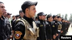 Shi'ite volunteers from Hezbollah Iraq who joined the Iraqi army to fight militants of the Islamic State, formerly known as the Islamic State in Iraq and the Levant, gather together in Baghdad, July 6, 2014.