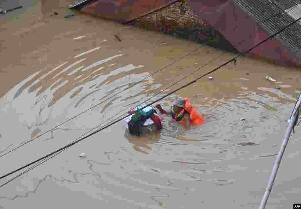 A resident makes his way during an evacuation as floods submerge some area along a river due to heavy rain in South Jakarta, Indonesia.