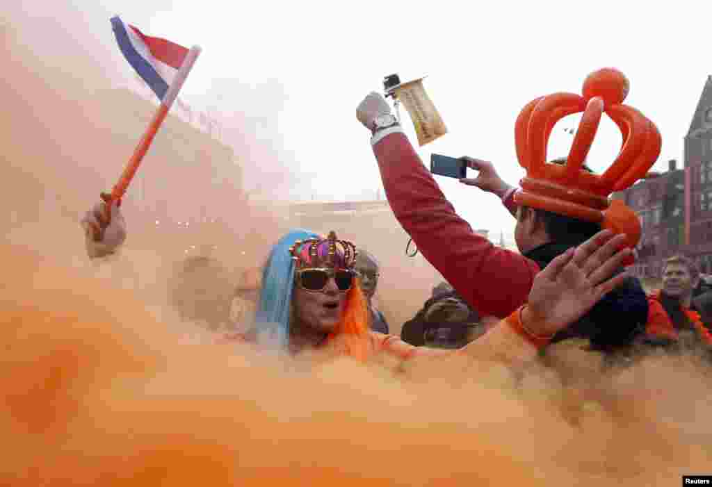 A woman celebrates the new Dutch King Willem-Alexander, who succeeds his mother Queen Beatrix, in Amsterdam&#39;s Dam Square.