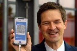 Ronald Fritz, manajer proyek di IBM, menunjukkan ponsel dengan model paspor vaksinasi digital (CovPass) di pusat vaksinasi Babelsberg di Potsdam dekat Berlin, Jerman timur laut, 27 Mei 2021. (AFP).