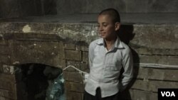 Seorang anak laki-laki Yazidi berdiri di dekat pintu masuk kuil Yazidi di Lalish, Irak.