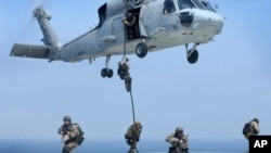 FILE - Navy SEALs training. SEALs are maritime special operations forces who strike from the sea, air and land.