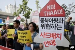 FILE - South Korean protesters shout slogans during a rally to oppose a plan to deploy an advanced U.S. missile defense system called Terminal High-Altitude Area Defense, or THAAD, near the U.S. Embassy in Seoul, South Korea, Oct. 20, 2016.