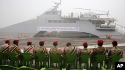 Members of Iran's Revolutionary Guard sit in front of a newly inaugurated high-speed catamaran, in the port city of Bushehr, northern Persian Gulf, Iran, Sept. 13, 2016.