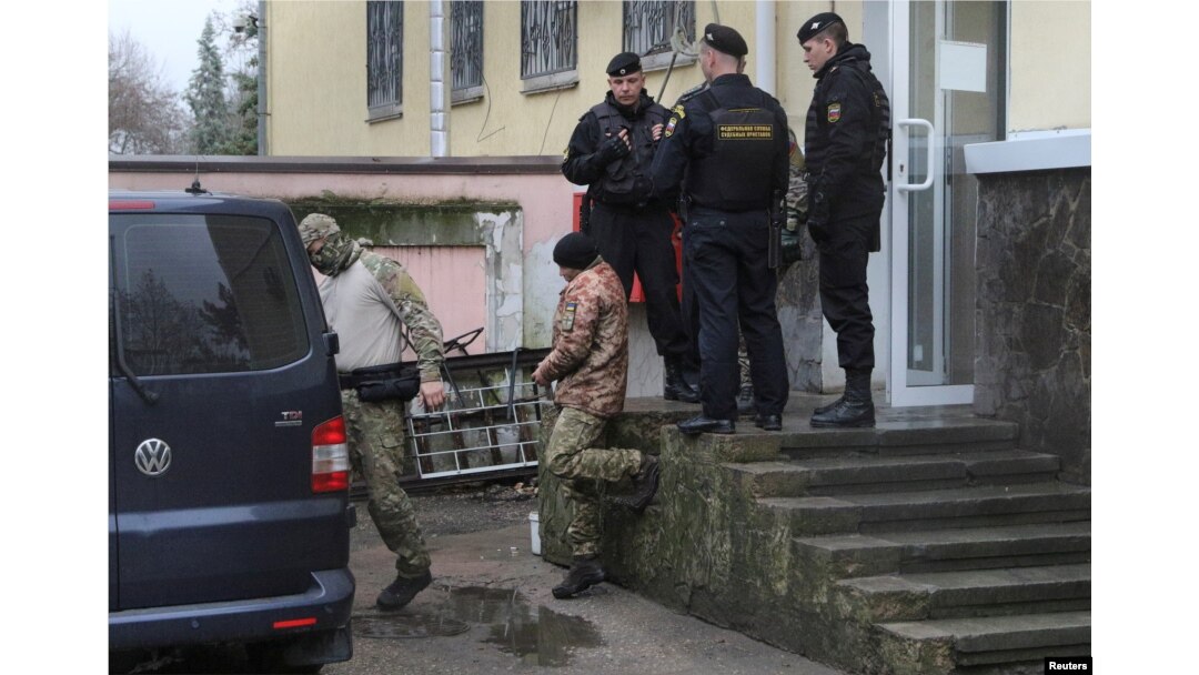 A crew member, center, of one of three Ukrainian naval ships attacked and seized Sunday by Russia is escorted after a court hearing in Simferopol, in Russia-annexed Crimea, Nov. 27, 2018.