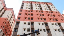 A construction worker fixes a window in a housing complex for people under the economic category of Below Poverty Line in Kolluru, on the outskirts of Hyderabad Feb. 1, 2022.