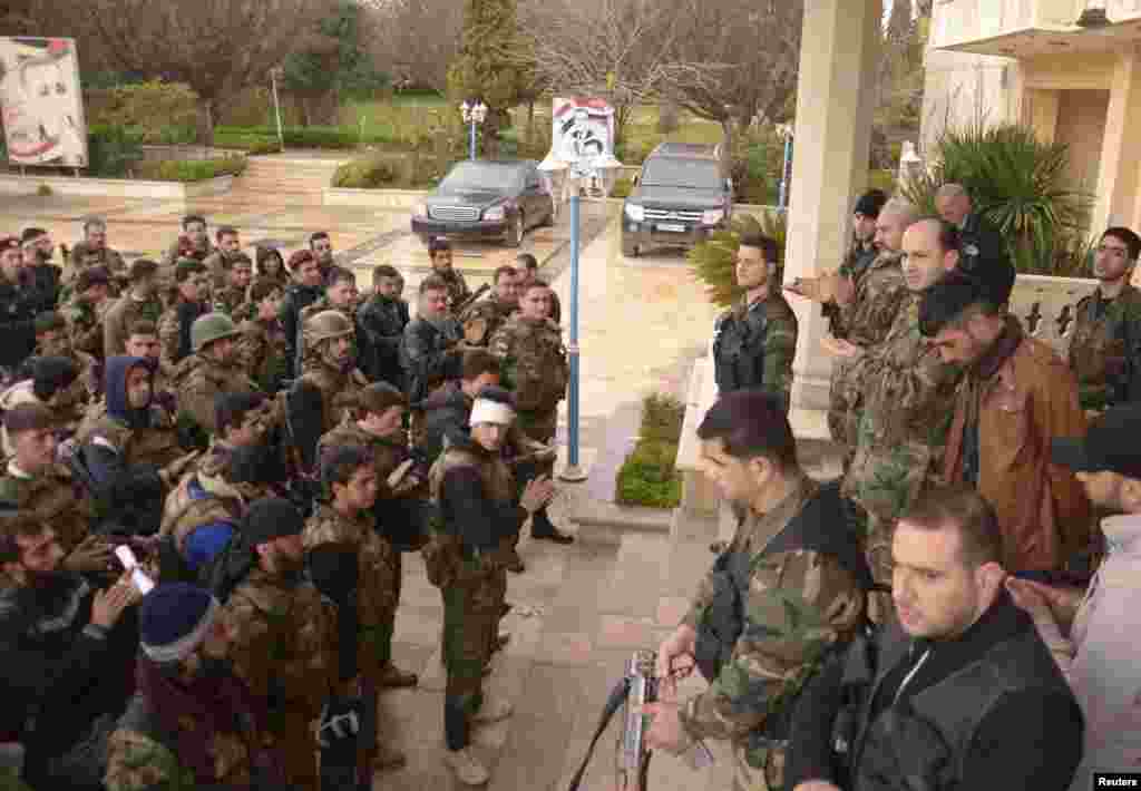 Forces loyal to Syrian President Bashar al-Assad applaud after being briefed in preparation for an offensive in the northern city of Aleppo, March 4, 2013.