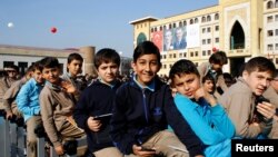 FILE - Students of Tevfik Ileri Imam Hatip School wait for the arrival of President Recep Tayyip Erdogan for an opening ceremony in Ankara, Turkey, Nov. 18, 2014. 