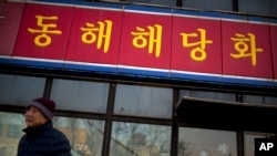 FILE - A man walks past a branch of the North Korean-operated Haedanghwa restaurant in Beijing. Officials did not say what country the group of defectors had been working in.