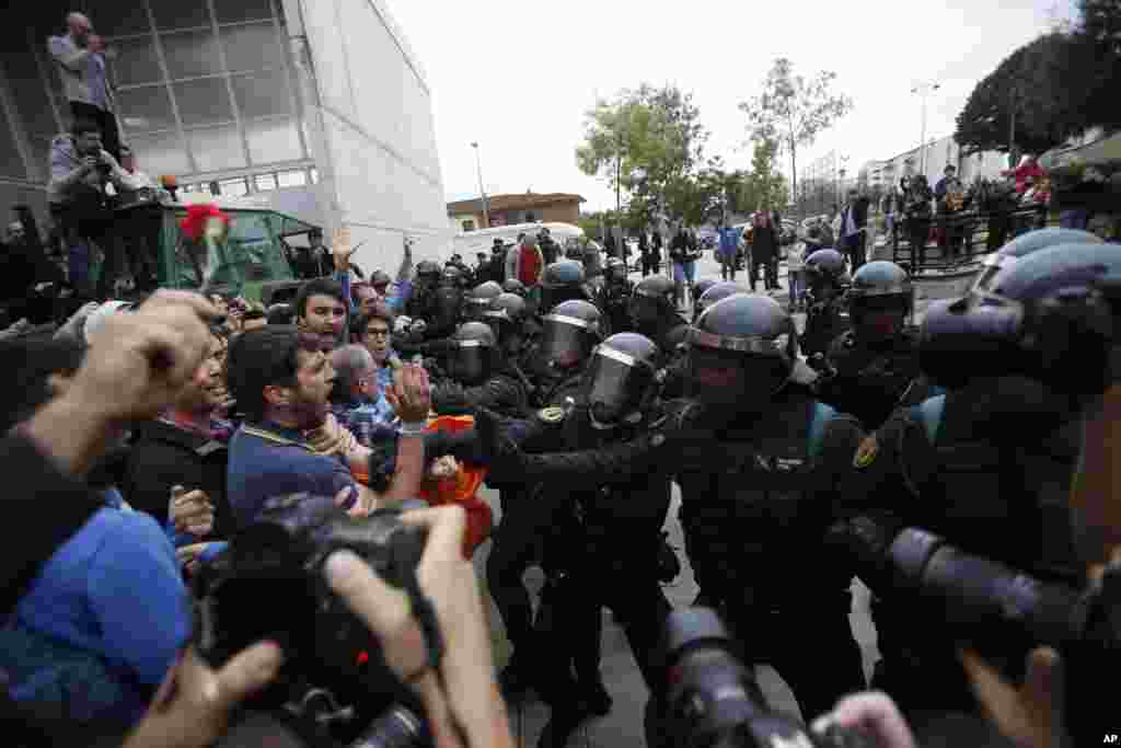 Правоохоронці відштовхують людей від входу до спортивного центру, який був призначений каталонським урядом виборчою дільницею, і де мав голосувати президент Каталоії Карлес Пучдемон. Сант Джулія де Раміс біля Жірони, Іспанія, 1 жовтня 2017 року.