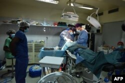 Para dokter bedah sedang melakukan tindakan pembedahan di Klinik Swasta Rochelle, di Abidjan, 14 Oktober 2017.