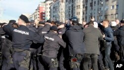 Serbian police officers and protesters clash during a protest in Belgrade, Serbia, Nov. 27, 2021.