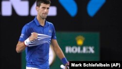 Novak Đoković proslavlja pobedu nad Lukom Puijem u polufinalu Australijen opena (Foto: AP/Mark Schiefelbein)
