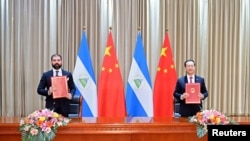 中国外交部副部长马朝旭（右）和尼加拉瓜代表在天津签署联合公报。（2021年12月10日）