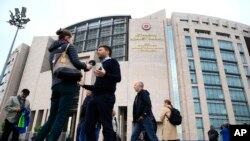 FILE - Human rights activists talk to the media as they stage a protest outside a court in Istanbul, Oct. 25, 2017. 