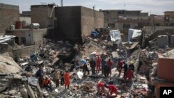 Les équipes de sauvetage de la protection civile recherchent des corps des personnes tuées ou d’éventuels survivants au milieu des débris d'une maison détruite lors des combats entre les forces de sécurité irakiennes et les militants de l'État islamique sur le côté ouest de Mossoul, Irak, 24 mars 2017.