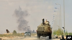 Anti-Gaddafi forces' armored personnel carrier advances to the front line at Teassain area, 90 km (56 miles) east of Sirte, amid heavy shelling by pro-Gaddafi forces, September 9, 2011.