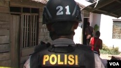 Seorang anggota polisi melakukan penyidikan di rumah korban penembakan kelompok tak dikenal bersenjata api di Desa Padalembara, Poso Pesisir Selatan (19/9).