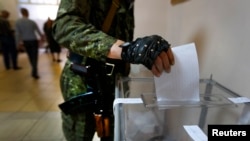 5月11日一名亲俄武装人员在乌克兰东部一投票站参加公投