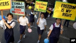 FILE - School girls hold placards as part of an awareness campaign against human trafficking in Kolkata, India, Feb. 15, 2015.