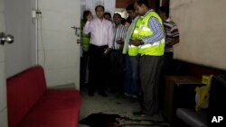 Bangladeshi security officers inspect the blood-stained site where publisher Ahmed Rahim Tutul and two writers were shot and stabbed by assailants in the office of the Shudhdhoswar publishing house, in Dhaka, Bangladesh, Oct. 31, 2015.