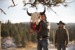 Mo, played by Mo Brings Plenty (L) raises a bison skull during a vision quest ceremony for Kayce Dutton, played by actor Luke Grimes, in Season 4, Episode 9 of Paramount+ series "Yellowstone"