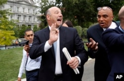 Director of the National Economic Council Gary Cohn, left, walks away from reporters after television interviews at the White House, Sept. 1, 2017, in Washington.