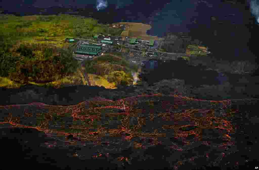 កម្អែល​ភ្នំ​ភ្លើង Kilauea ហូរ​នៅ​ក្បែរ​រោងចក្រ​ផលិត​អគ្គិសនី Puna Geothermal Venture នៅ​ក្នុង​ក្រុង Pahoa រដ្ឋ Hawaii កាលពី​ថ្ងៃទី១០ ខែមិថុនា ឆ្នាំ២០១៨។