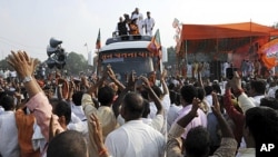 Supporters wave as India's opposition Bharatiya Janata Party's senior leader Lal Krishna Advani, left atop the bus, begins his journey for a nationwide campaign against corruption at Chaapra district in Bihar state, India, October 11, 2011. (AP)