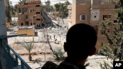 A Syrian Democratic Forces (SDF) fighter stands on a balcony in Raqqa, Syria, June 27, 2017. 