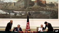 Abdullah Abdullah, second left, and Ashraf Ghani Ahmadzai, second right, sign a power-sharing deal at the presidential palace in Kabul, Afghanistan, Sept. 21, 2014. (AP Photo/Massoud Hossaini)