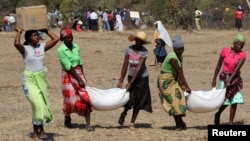 file: Villagers collect their monthly food aid provided by United Nations World Food Programme (WFP) in Bhayu, Zimbabwe.